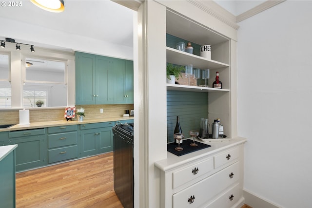 interior space with light wood-type flooring, backsplash, and gas stove