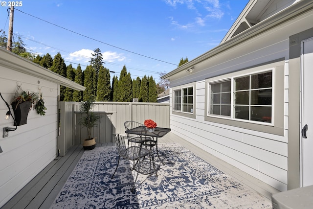 wooden terrace featuring outdoor dining area and fence