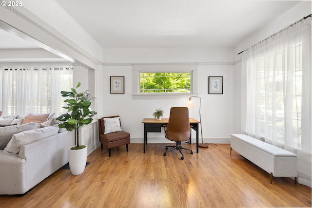 office space featuring baseboards and light wood finished floors