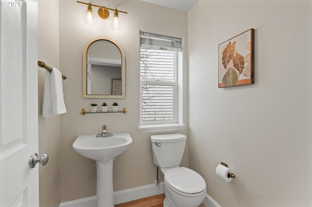 bathroom featuring baseboards and toilet