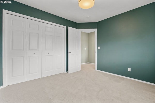 unfurnished bedroom with a closet, baseboards, and carpet floors