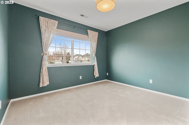 carpeted empty room with baseboards and visible vents