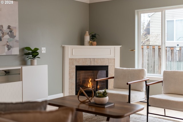 sitting room with a tile fireplace and baseboards