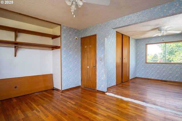 13530 NE Milton St, Portland, OR 97230 - unfurnished bedroom with wallpapered walls, a textured ceiling, wood finished floors, and ceiling fan