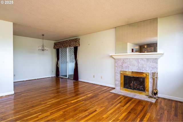 13530 NE Milton St, Portland, OR 97230 - unfurnished living room featuring a chandelier, wood finished floors, a tiled fireplace, and a textured ceiling