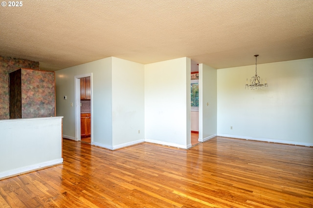 13530 NE Milton St, Portland, OR 97230 - empty room featuring a chandelier, light wood-style floors, and a textured ceiling