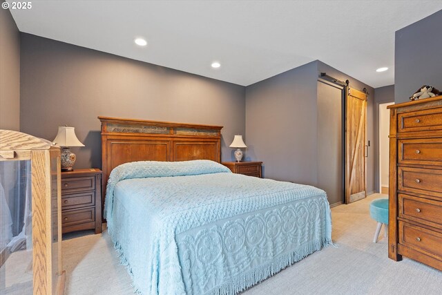 bedroom featuring a barn door and light colored carpet