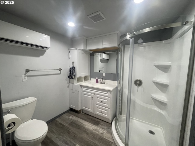 bathroom with a shower with door, a wall unit AC, vanity, wood-type flooring, and toilet