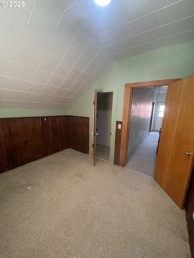 bonus room featuring lofted ceiling and light carpet