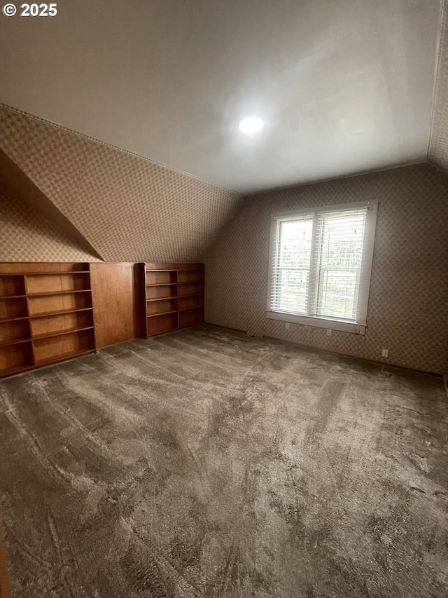 bonus room with carpet floors and vaulted ceiling