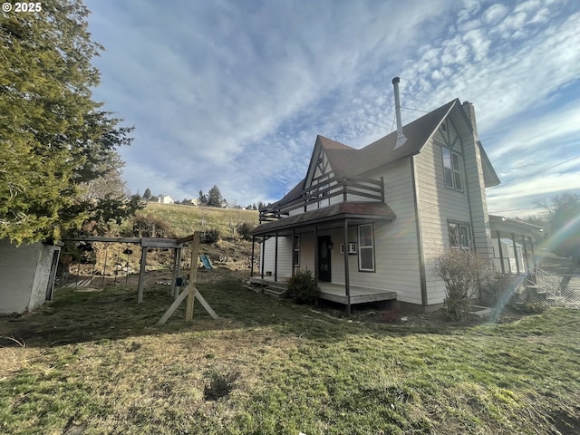 view of side of home with a playground and a lawn