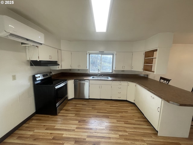 kitchen with sink, light hardwood / wood-style flooring, appliances with stainless steel finishes, white cabinetry, and a wall unit AC