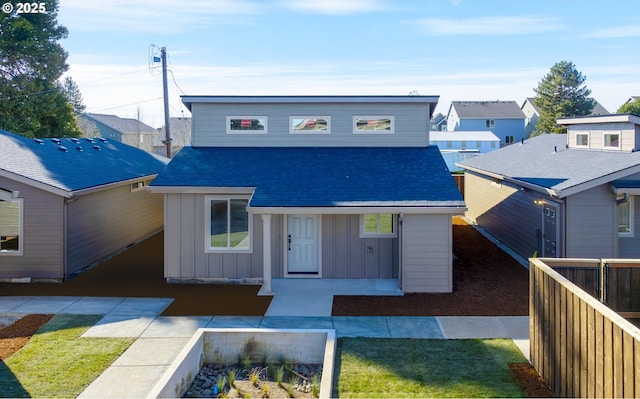 view of front of house with a shingled roof, a residential view, and board and batten siding