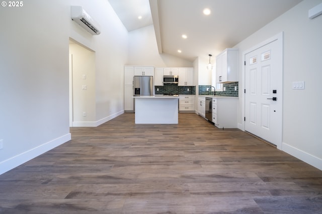 kitchen featuring stainless steel appliances, light countertops, an AC wall unit, white cabinets, and a kitchen island