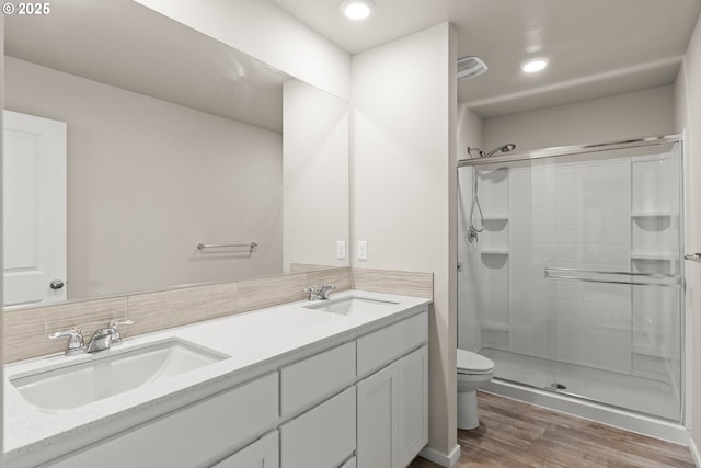 15470 NW Blueblossom St, Portland, OR 97229 - bathroom with wood finished floors, a stall shower, double vanity, tasteful backsplash, and recessed lighting