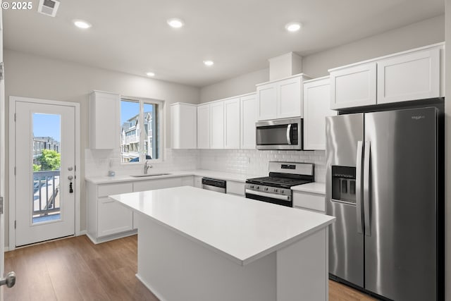 15470 NW Blueblossom St, Portland, OR 97229 - kitchen featuring appliances with stainless steel finishes, a center island, light countertops, tasteful backsplash, and recessed lighting