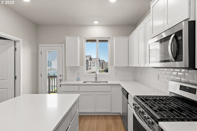 15470 NW Blueblossom St, Portland, OR 97229 - kitchen featuring appliances with stainless steel finishes, plenty of natural light, light wood finished floors, recessed lighting, and white cabinets