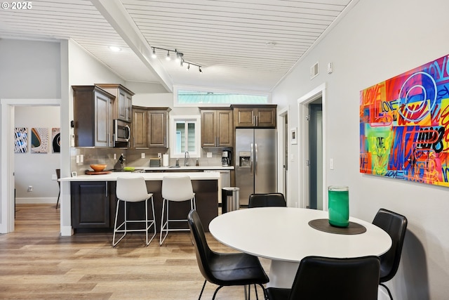 dining area with rail lighting, light hardwood / wood-style flooring, and sink