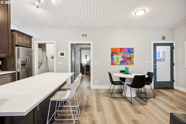 kitchen featuring a kitchen bar, a center island, stainless steel appliances, and dark brown cabinetry