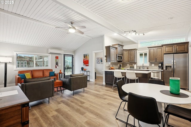 dining room with ceiling fan, sink, a wall unit AC, light hardwood / wood-style floors, and lofted ceiling