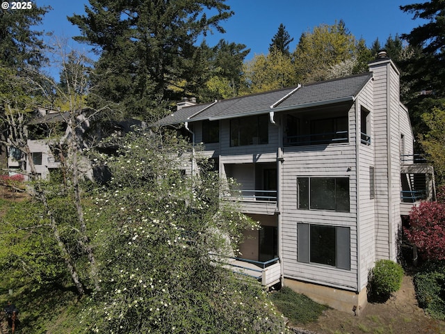 exterior space with a balcony and a chimney