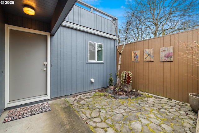 property entrance featuring a patio area and fence