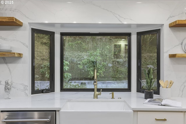 details featuring sink, dishwasher, and light stone counters