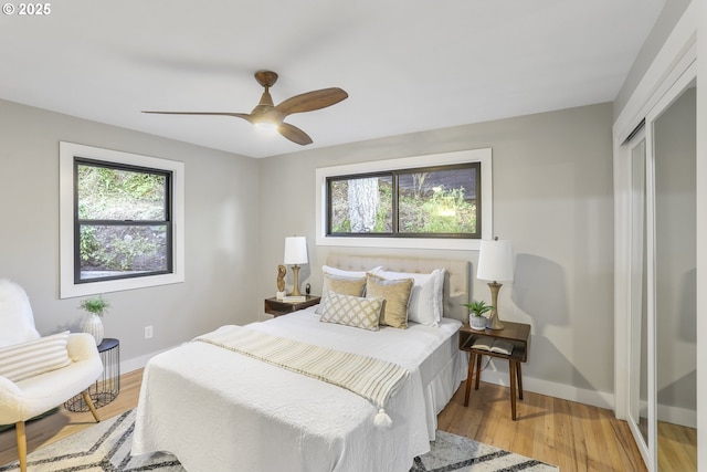 bedroom with wood-type flooring, multiple windows, a closet, and ceiling fan