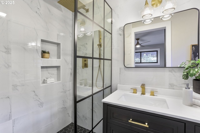 bathroom featuring ceiling fan, a tile shower, and vanity