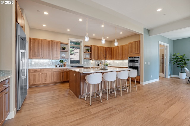 14 Juarez St, Lake Oswego, OR 97035 - kitchen featuring stainless steel double oven, high end fridge, open shelves, a kitchen island with sink, and a breakfast bar