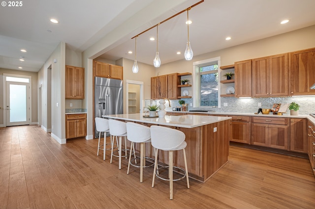 14 Juarez St, Lake Oswego, OR 97035 - kitchen with high end refrigerator, open shelves, a kitchen island, a breakfast bar area, and light wood-type flooring