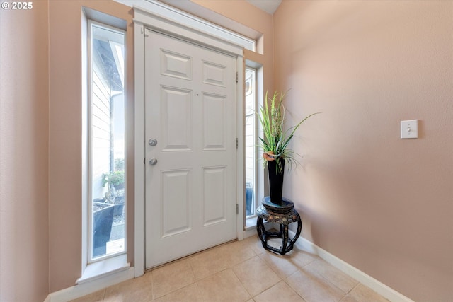 entrance foyer featuring a wealth of natural light, baseboards, and light tile patterned flooring