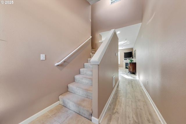 stairs with visible vents, baseboards, and wood finished floors
