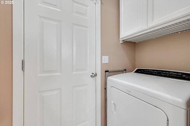clothes washing area with cabinet space and washer / dryer