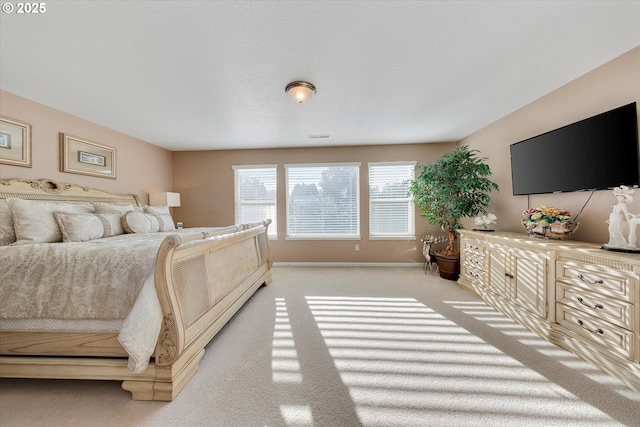 bedroom featuring light carpet and baseboards