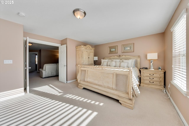bedroom with baseboards and light carpet