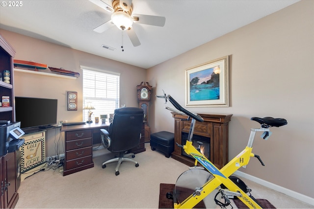 carpeted office space with visible vents, baseboards, and a ceiling fan