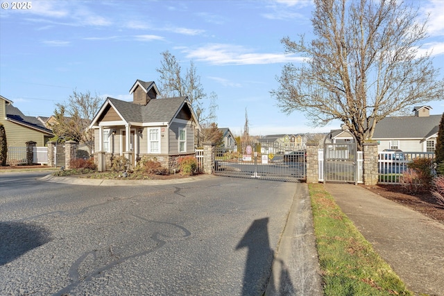view of road with sidewalks, curbs, a gated entry, and a gate