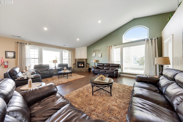 living room with visible vents, dark wood-type flooring, high vaulted ceiling, recessed lighting, and a large fireplace