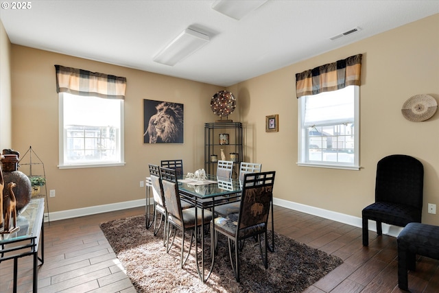 dining space featuring a wealth of natural light, visible vents, and wood finished floors