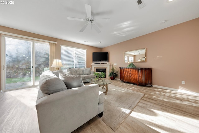 living area featuring ceiling fan, visible vents, a healthy amount of sunlight, and light wood-style flooring