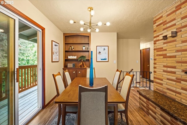 4819 SW Hamilton St, Portland, OR 97221 - dining room featuring wood finished floors, a chandelier, a textured ceiling, and built in features