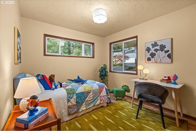bedroom featuring a textured ceiling and baseboards