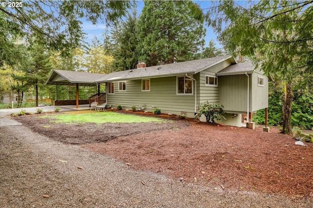 4819 SW Hamilton St, Portland, OR 97221 - view of front of house with dirt driveway, a chimney, and a carport