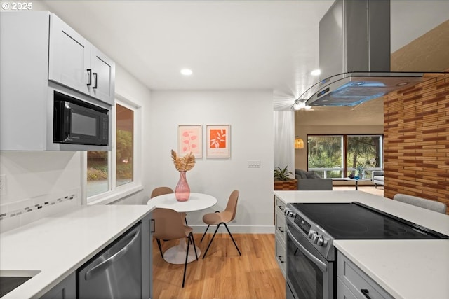 4819 SW Hamilton St, Portland, OR 97221 - kitchen featuring electric stove, black microwave, dishwasher, island range hood, and light countertops