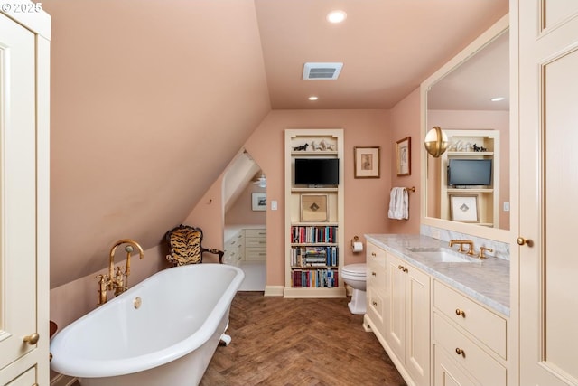 bathroom with wood finished floors, built in features, vanity, a soaking tub, and lofted ceiling