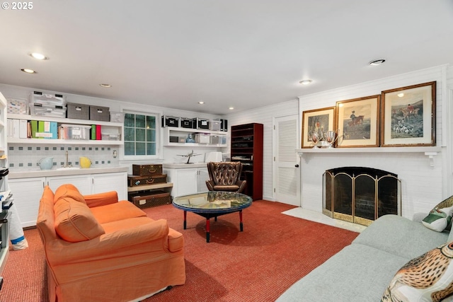 living area with a fireplace, recessed lighting, and carpet floors