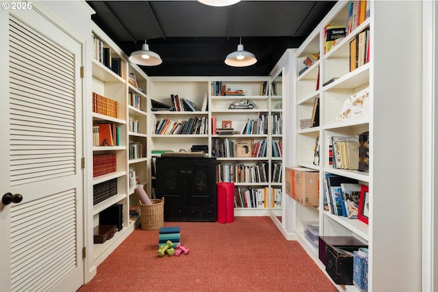sitting room with bookshelves and carpet flooring