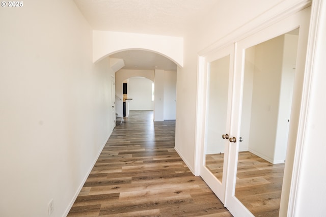 24823 Hawks View Dr, Veneta, OR 97487 - corridor with wood finished floors, arched walkways, and french doors