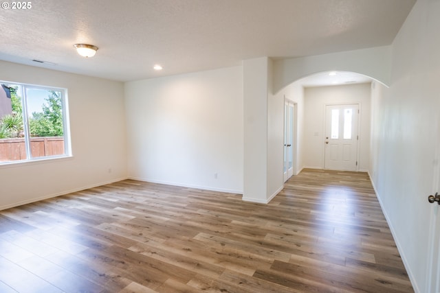 24823 Hawks View Dr, Veneta, OR 97487 - unfurnished room with arched walkways, wood finished floors, and recessed lighting